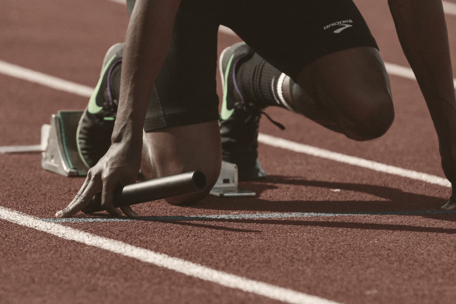 Sprinter mid-stride: explosive movement, warm dust